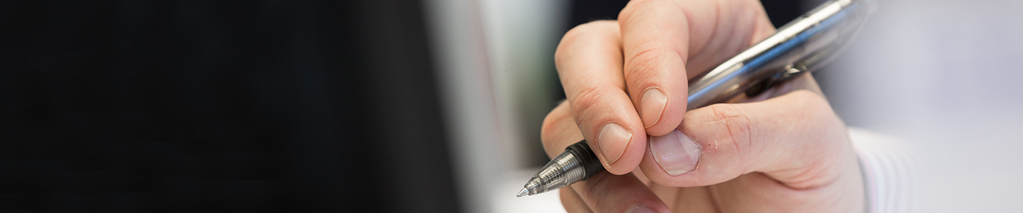  A hand marking up Financial Print documentation around the clock